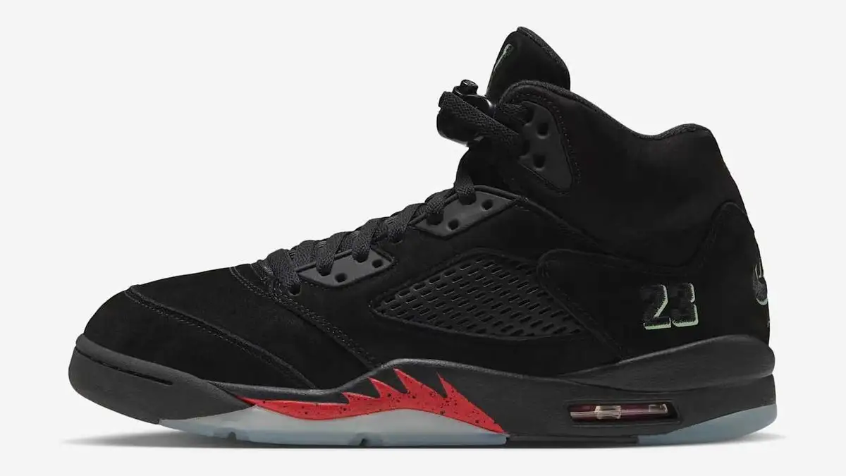 Air Jordan 5 Retro Halloween in black suede with a red flame detail on the midsole and an icy translucent sole, side view on a light grey ground.